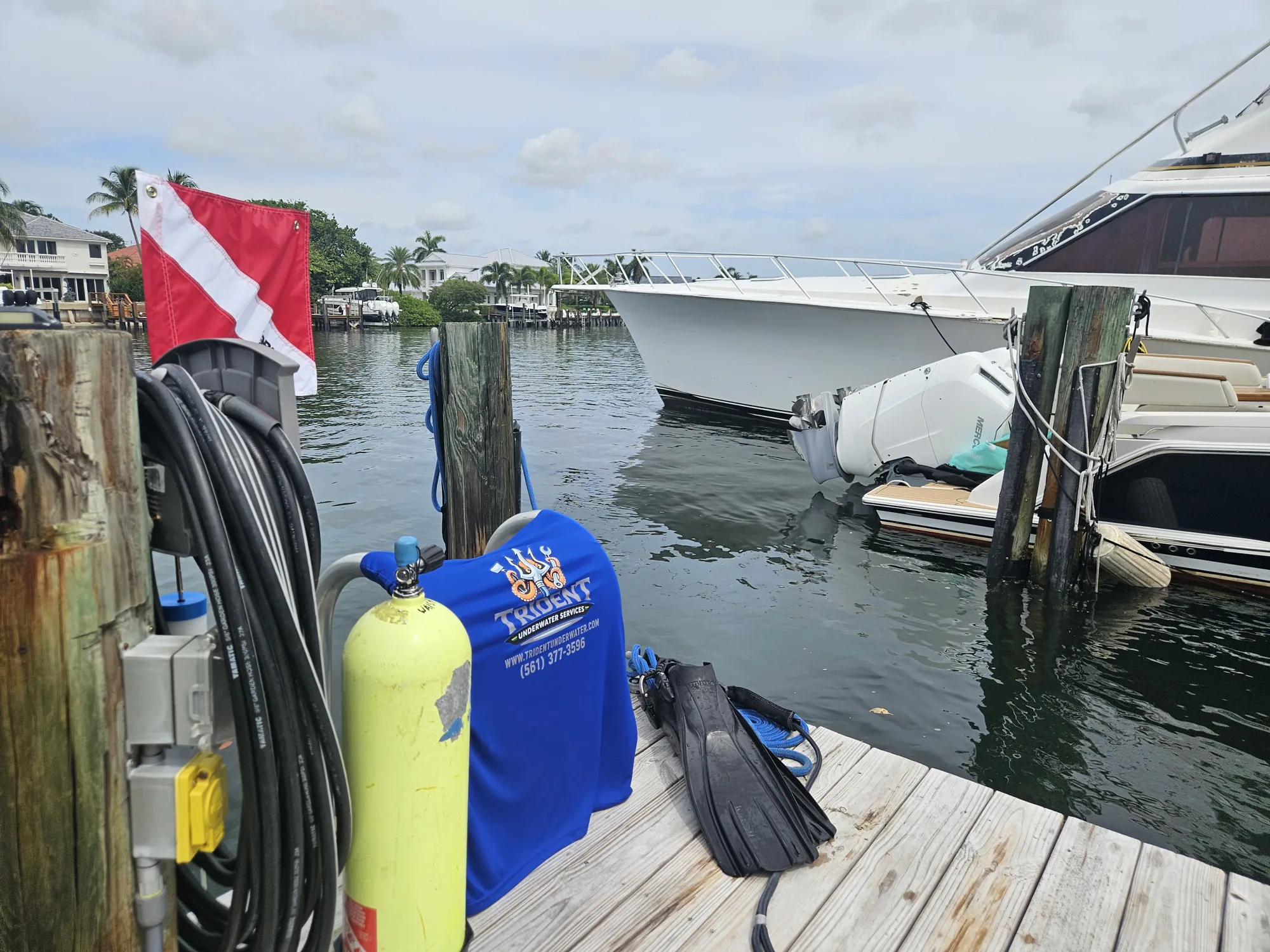 Commercial dive gear staged on the dock with the dive flag up